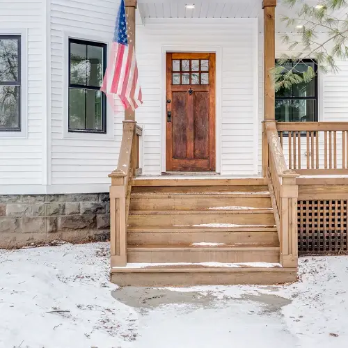 Custom wood porch deck with American flag and solid craftsmanship by Union Properties in Huron, MI