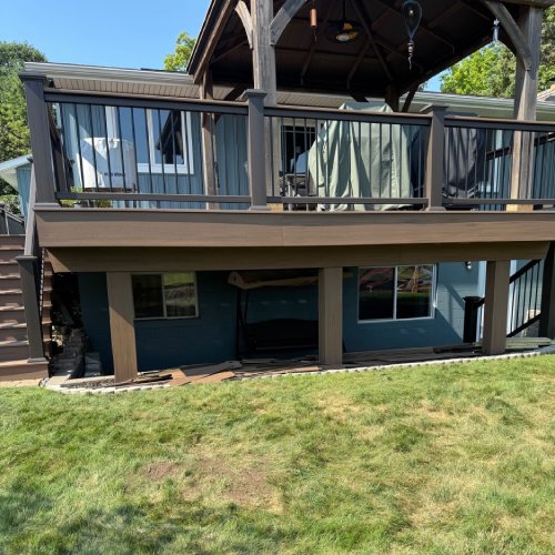 Composite deck with railing and covered patio by Union Properties in Mi