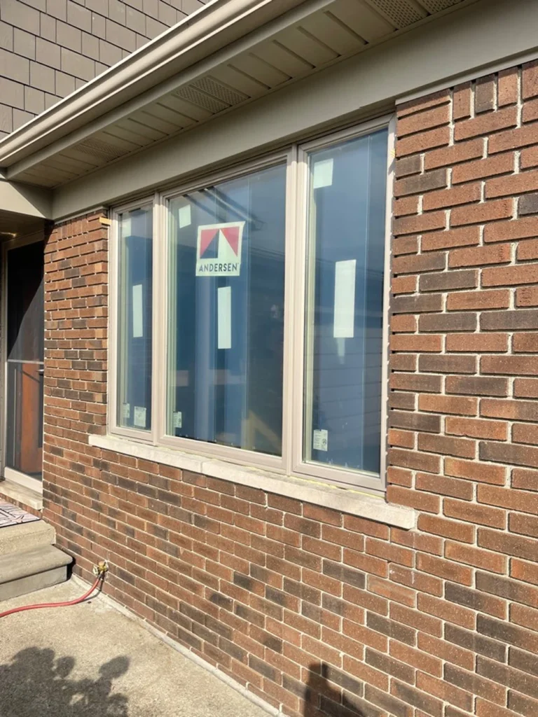 Newly installed Andersen vinyl window on brick home by Union Properties in Huron, MI₹