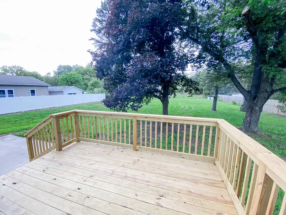 Small wooden backyard deck overlooking open lawn by Union Properties in Huron, MI