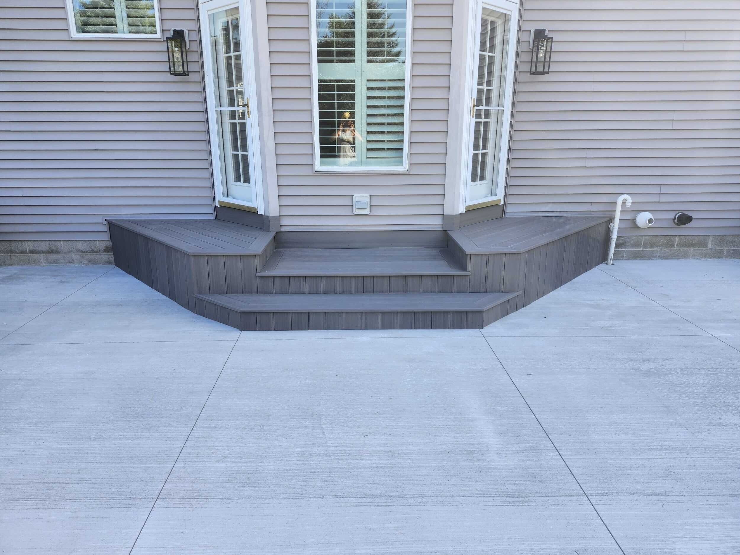 Gray deck with concrete patio multi-level decks Michigan service in Michigan by Union Properties