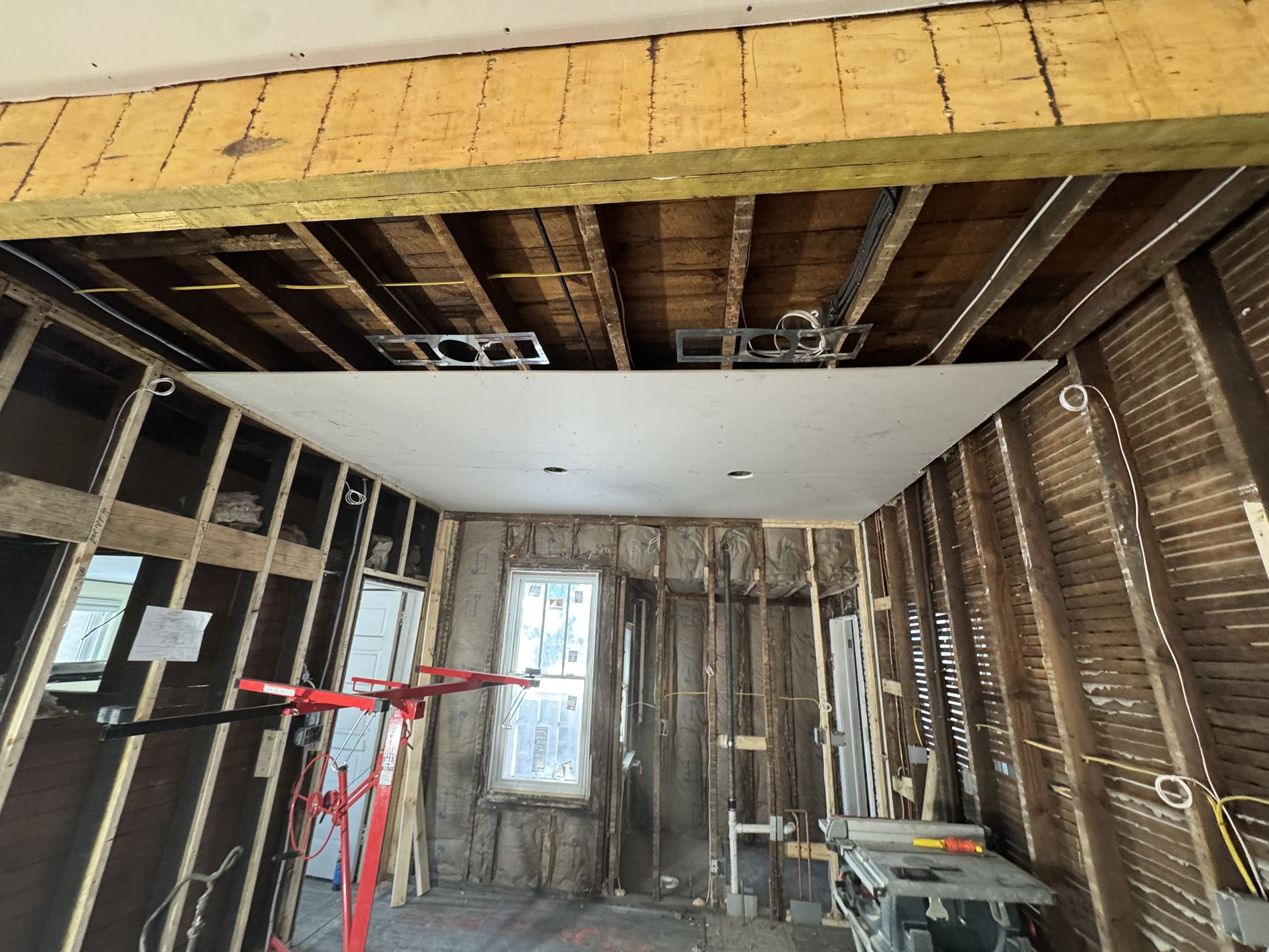 Exposed studs, insulation, and wiring during a home renovation, illustrating what is a general contractor overseeing construction in Port Huron