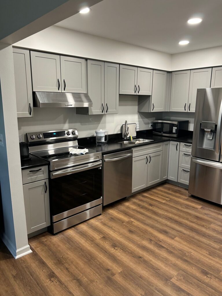 new kitchen installation with gray cabinets and stainless steel appliances. A remodel project by Union Properties in Port Huron, MI